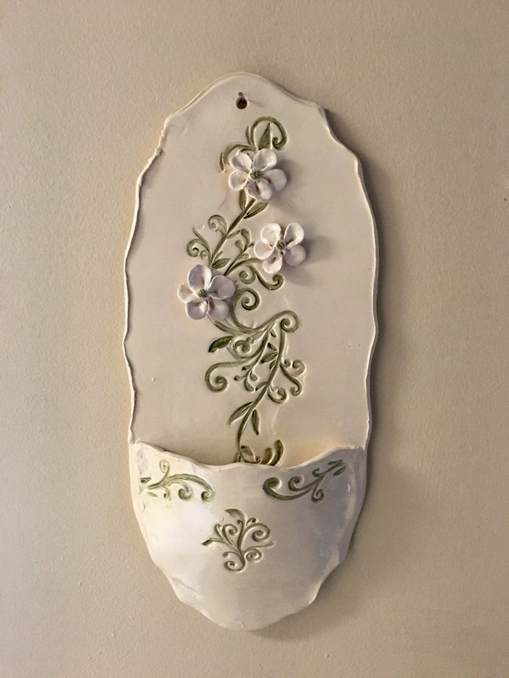 a white wall hanging with flowers on it