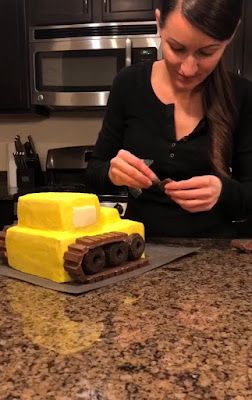 a woman standing in front of a cake with yellow frosting on top of it