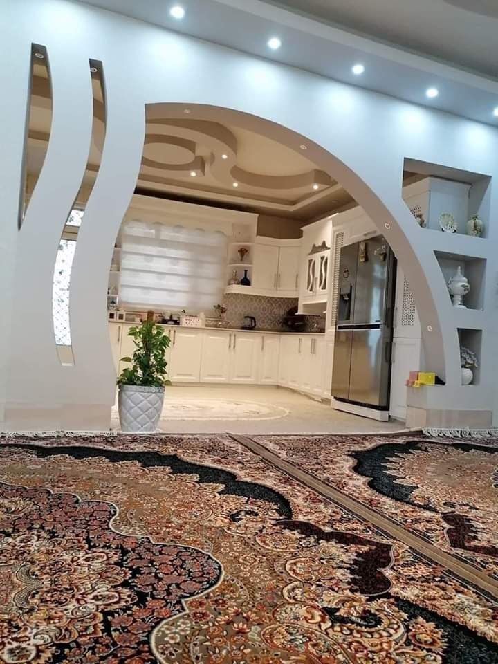 a large area rug in the middle of a room with an archway leading into it