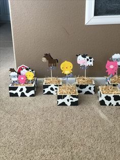 there are some little farm animals in the boxes on the floor with straw and hay