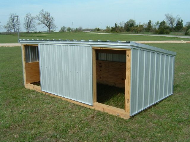 a small metal shed sitting on top of a lush green field