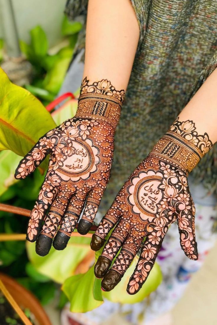 a woman's hands with hennap on her arm and hand, showing the intricate