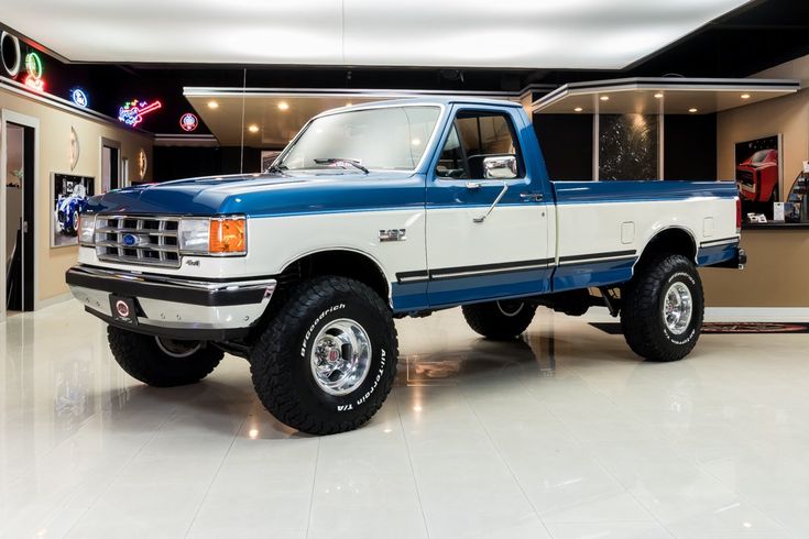 a blue and white pickup truck in a showroom