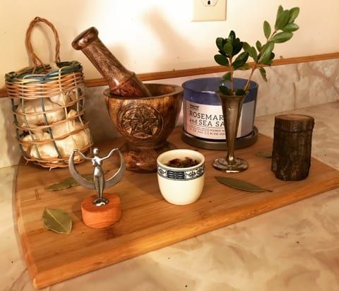 there is a wooden tray with various items on it and a potted plant in the middle