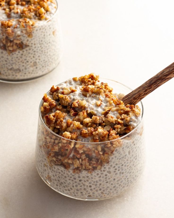 two glasses filled with oatmeal and walnuts