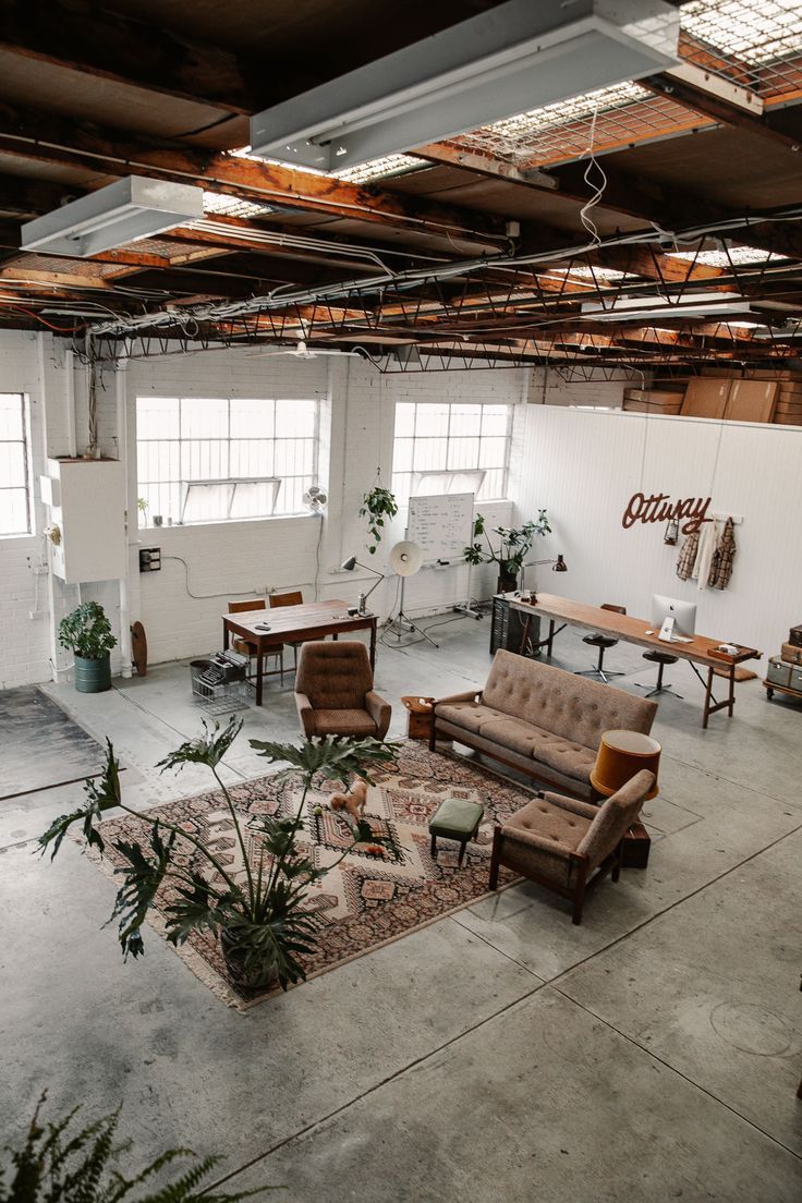 an office with couches, chairs and tables in the middle of the room that is empty