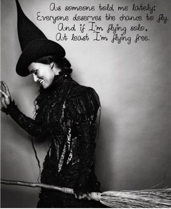 black and white photograph of a woman wearing a witches hat with words written on it