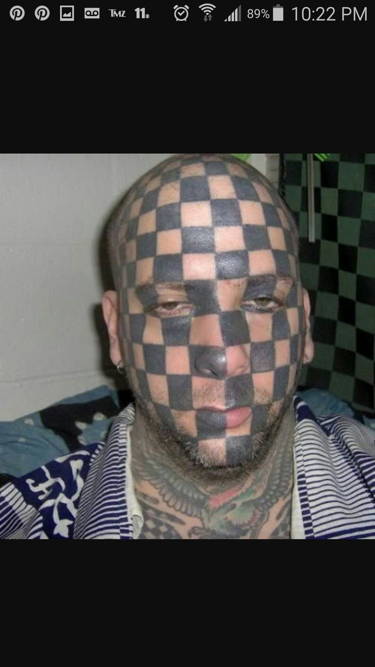 a man with his face painted like a checkerboard pattern on the forehead and chest