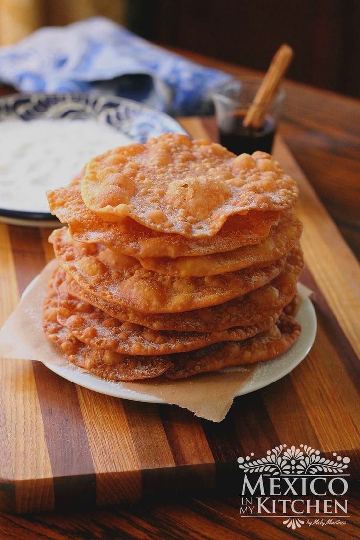 a stack of pancakes sitting on top of a wooden cutting board