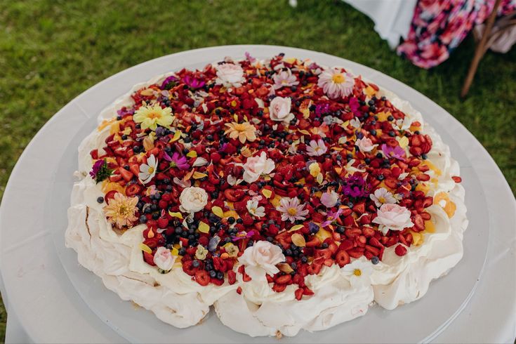 a cake with white frosting and colorful toppings on it sitting on a table