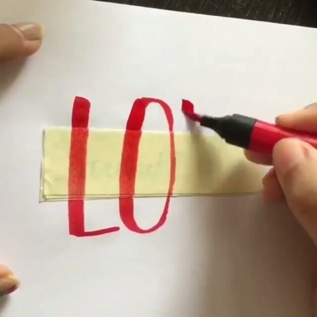 someone is cutting out the word love on paper with a crayon pen and marker