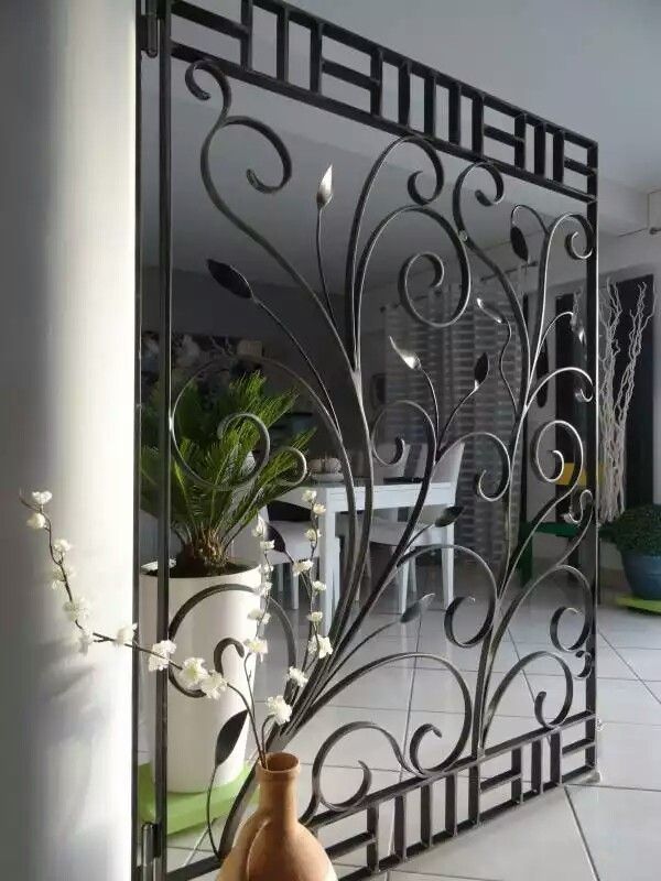 a vase sitting on top of a table next to a glass door with an intricate design