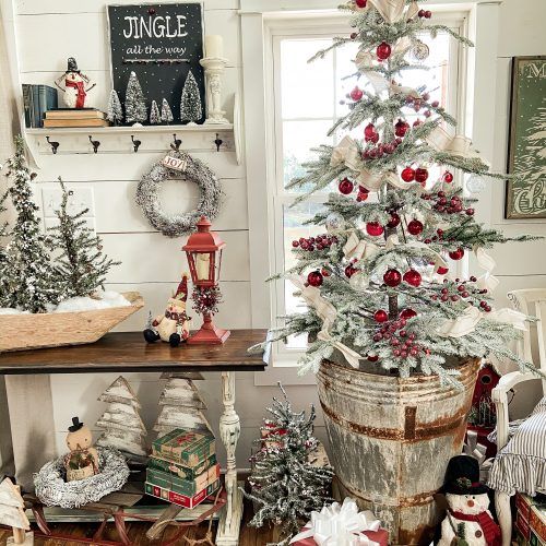 a small christmas tree in a bucket on the floor next to other ornaments and decorations