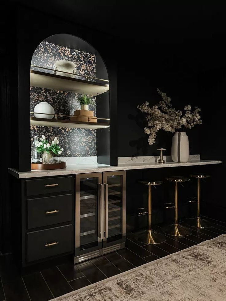 a kitchen with black walls and gold accents