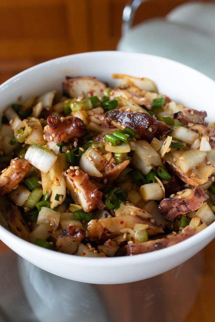 a white bowl filled with food on top of a table