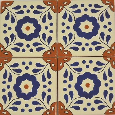 an artistic tile design with blue and orange flowers on white tiles, which are hand painted in different colors