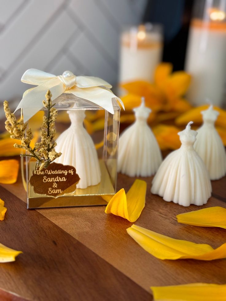 wedding favors are sitting on a table with yellow petals