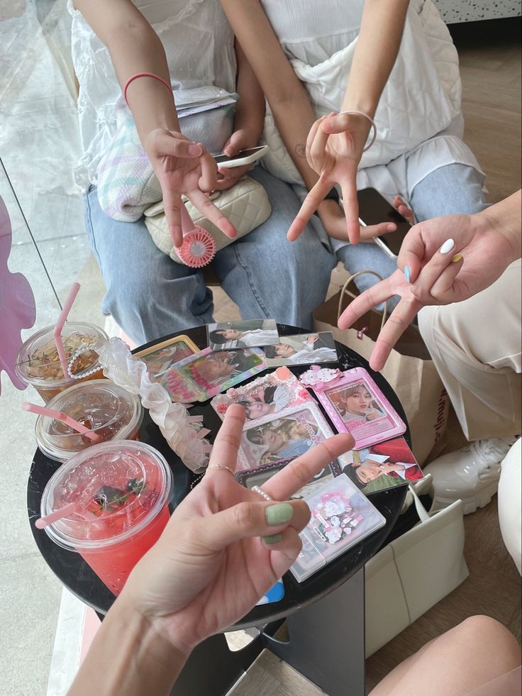 three people sitting on a table holding up their fingers