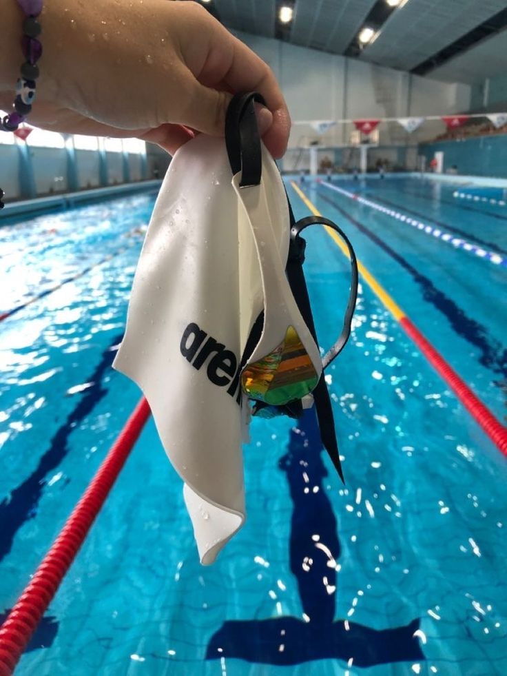 someone is holding a towel over the edge of a swimming pool with water in it