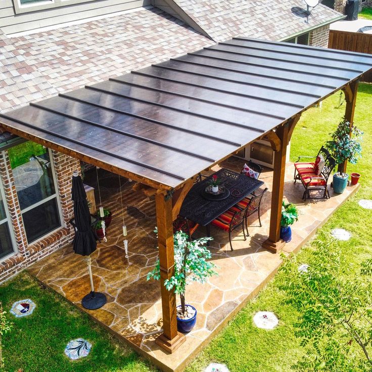 a covered patio with table and chairs in the yard