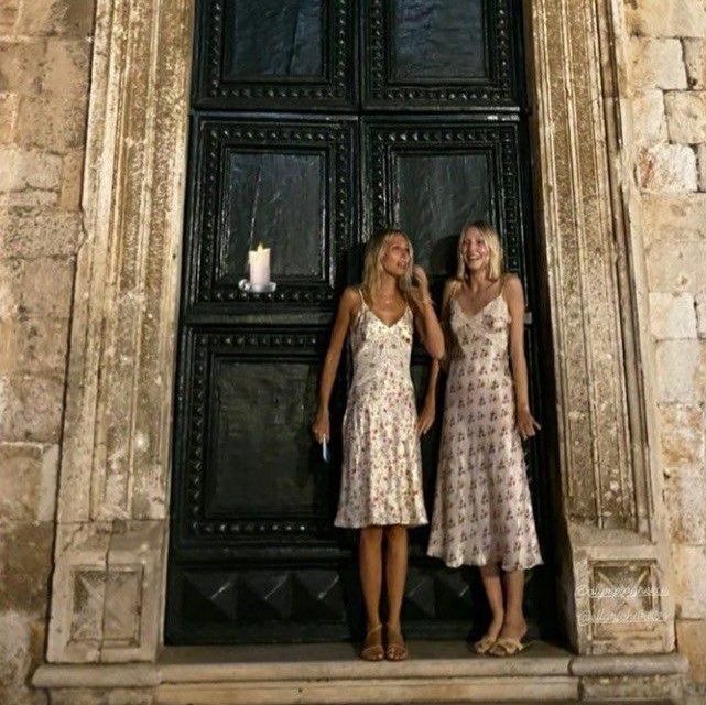 two women are standing in front of a door