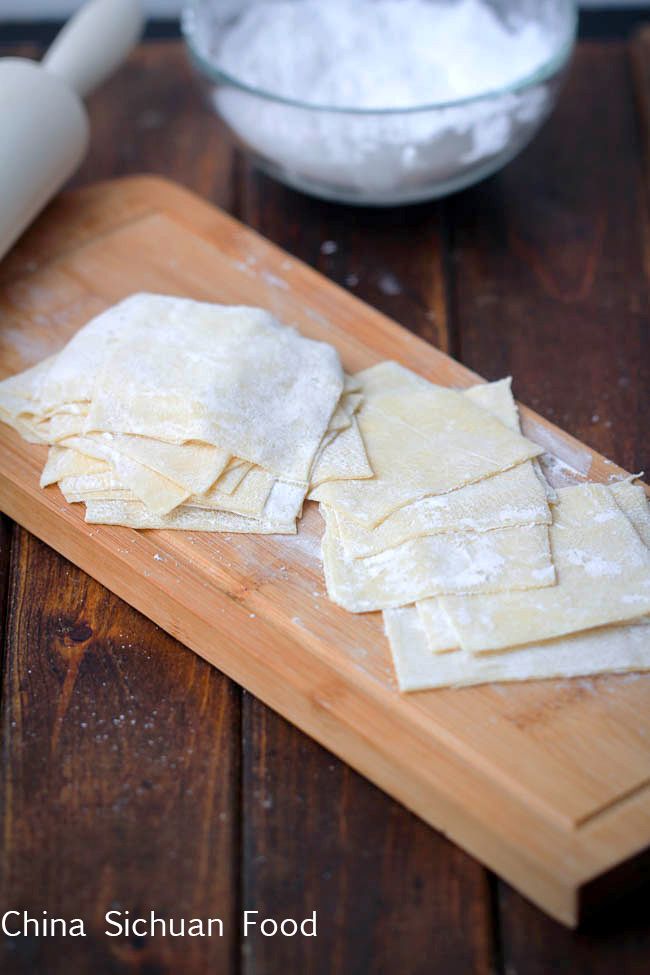 some food is laying out on a cutting board next to a bowl and rolling pin