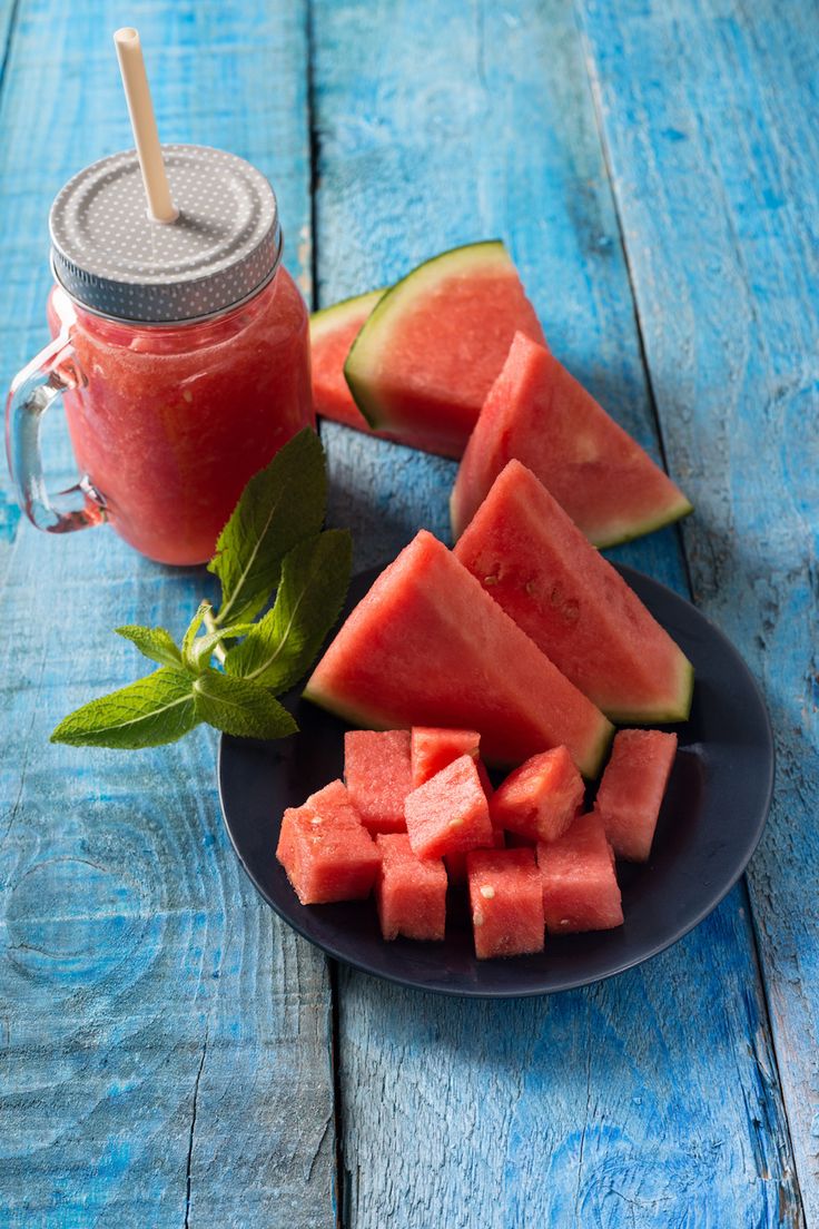 slices of watermelon on a plate next to a mason jar