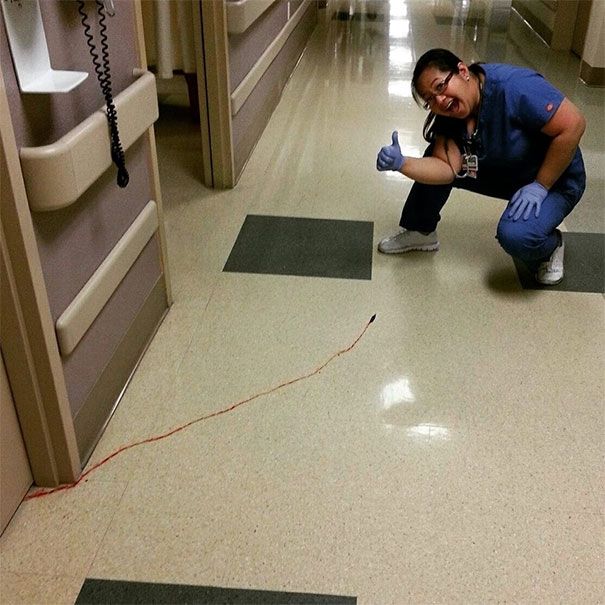 a woman kneeling down on the floor in a hospital hallway