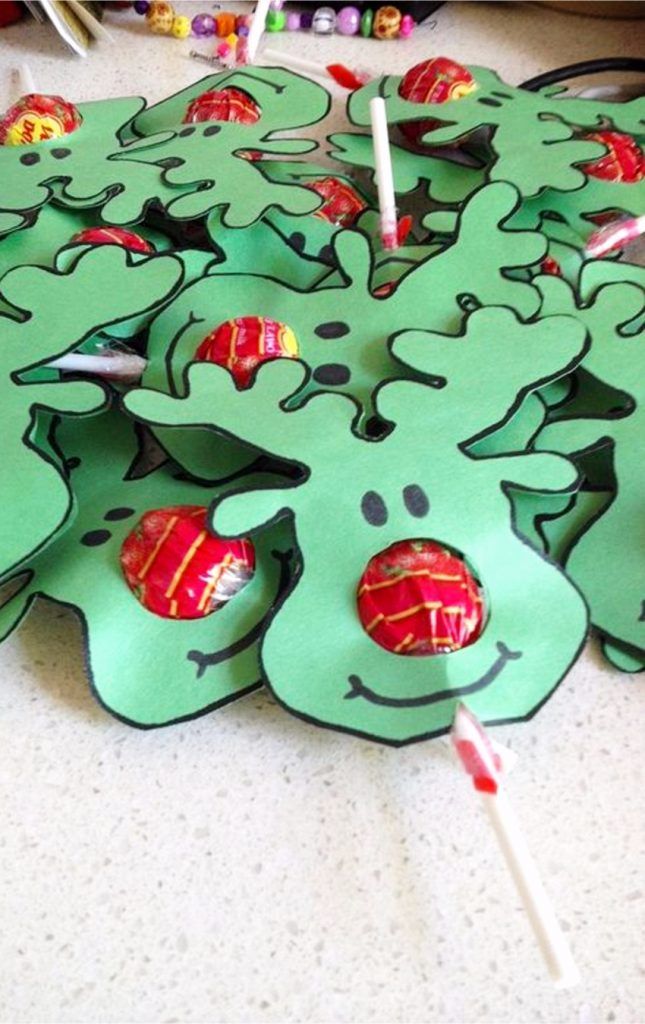 a table topped with green paper cut outs covered in candies and lollipops