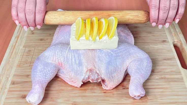 a person holding a large piece of meat with lemon slices on it