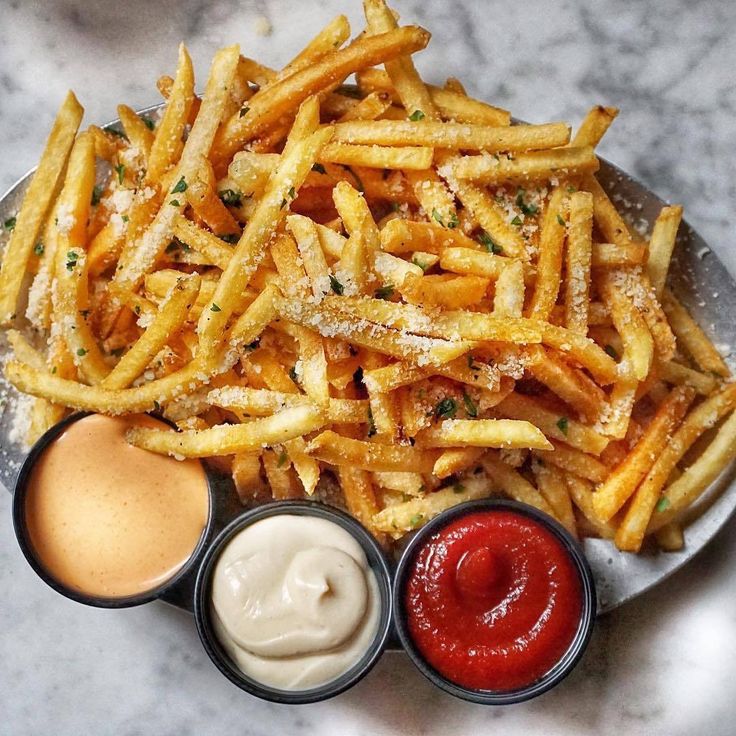 french fries, ketchup and mayonnaise on a plate with sauces