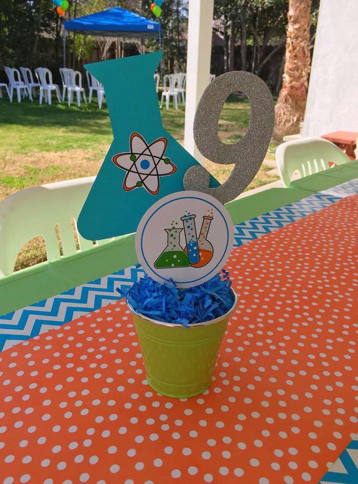 a cup with some candy in it sitting on a table near a number 9 sign