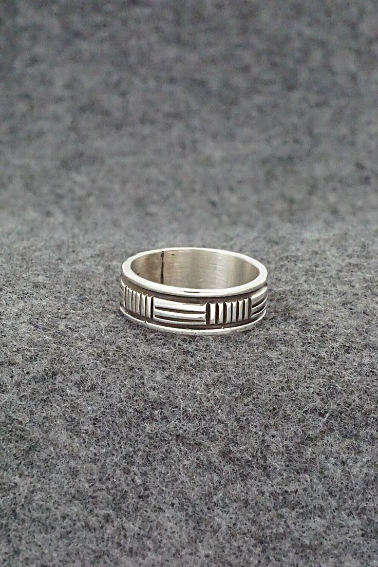 This sterling silver ring was made by Navajo silversmith Bruce Morgan. The inside is signed B Morgan and stamped sterling.Size: 7.5Length: 1/4"Free shipping on all orders! We ship with USPS and always include tracking. All orders ship within a day of payment.Returns are accepted up to 30 days after you receive your order. Just send us a message. Our shop offers cash back or store credit. The item must be returned in new condition. Artisan Engraved Sterling Silver Ring 925, Artisan Sterling Silver Ring With Etched Details, Artisan Sterling Silver Etched Rings, Sterling Silver Engraved Wide Band Ring, Southwestern Sterling Silver Rings For Anniversary, Silver Southwestern Style Rings, Southwestern Style Untreated Silver Rings, Sterling Silver Etched Ring With Round Band, Etched Sterling Silver Round Band Ring