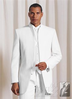 a man in a white tuxedo poses for the camera with his hands in his pockets