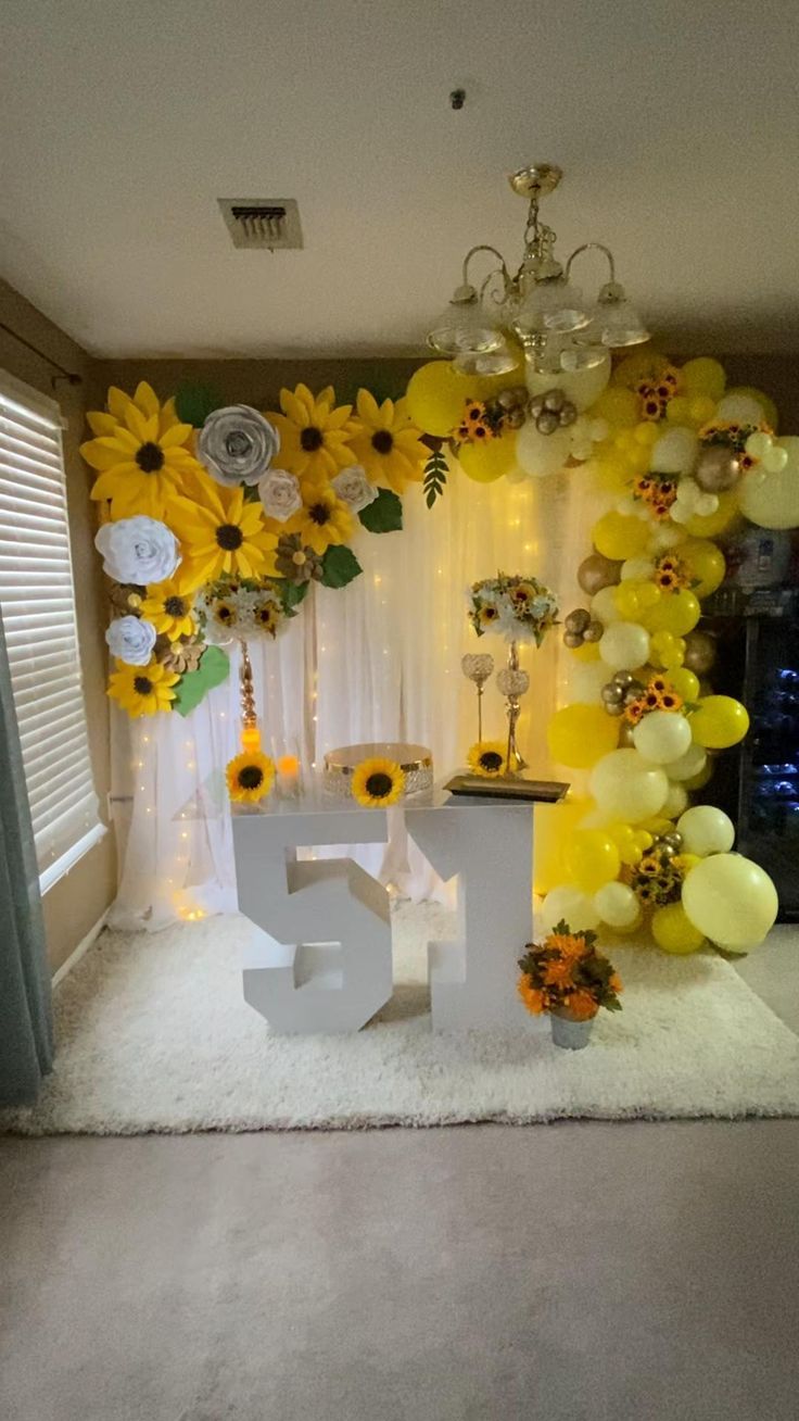 a decorated room with balloons and sunflowers