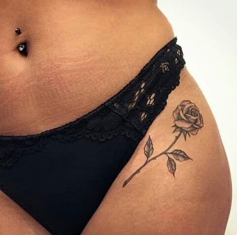 a woman's stomach with a rose tattoo on her belly and the bottom part of her panties