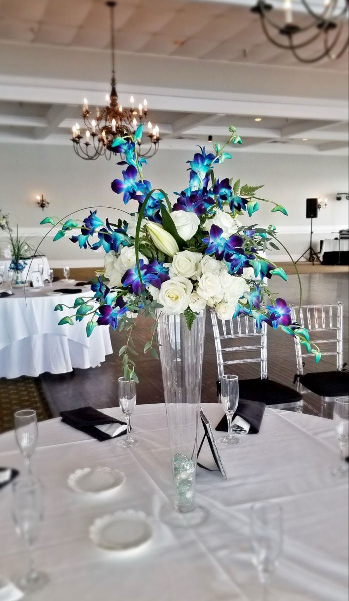 a vase filled with blue and white flowers sitting on top of a dining room table