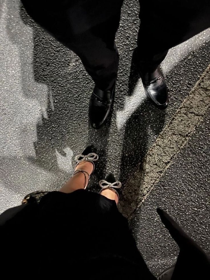 two people standing next to each other with their feet on the ground and one person wearing black shoes