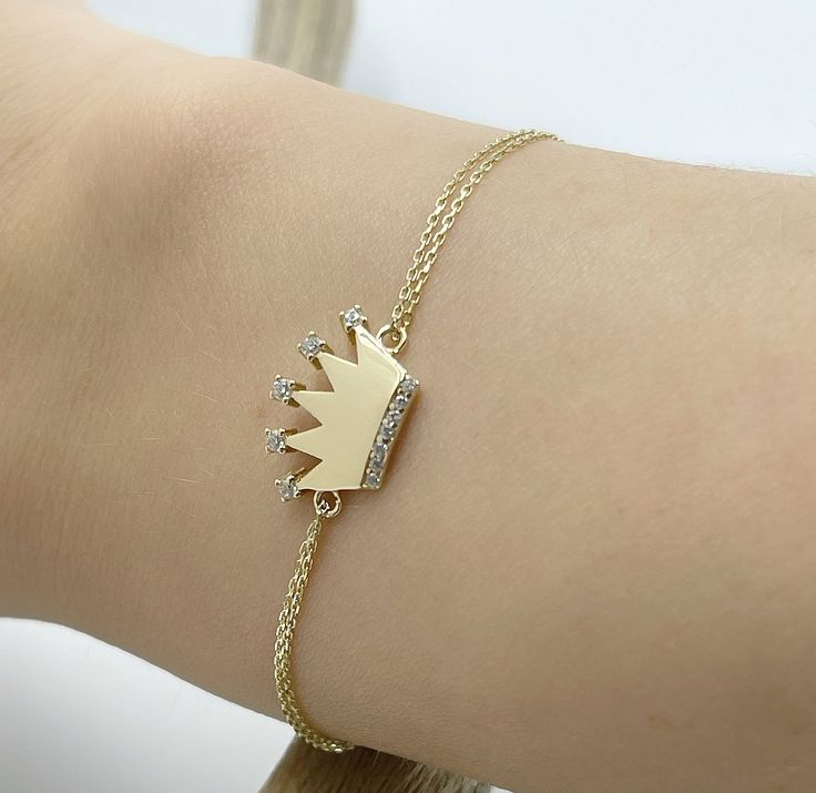 Crown Bracelet, 14k Solid Gold Bracelet, Queen Bracelet , Bridesmaid Gift, Wedding Gift, Anniversary Gift, Christmas gift, Birthday Gift. Product Details  ✪ Handmade / Handcrafted Fine Jewelry  ✪ Gold Weight: Approx. 1,75g   ✪ Metal:  14K Solid Gold   ✪ Gold Color: White gold, Rose gold, Yellow gold ♡ For questions or special designs, please contact us via message. We are happy to hear from our customers and always respond quickly. Comments are always valuable. 🎁 TRANSPORTATION You can put your choice in the cart, it will be in stock and shipped within 24 hours! . Deliveries are made within 3-5 days. We are not responsible for customs duties incurred during international orders. ☎ Please leave your phone number at the checkout for shipment purposes. 🌎 RETURN POLICY Satisfaction guarantee 14k Yellow Gold Bracelet Gift, Gift 14k Yellow Gold Bracelet, Fine Jewelry Bracelets With Diamond Accents For Gifts, Adjustable Gold Bracelet With Diamond Accents For Formal Occasions, 14k Yellow Gold Bracelet As Gift, Dainty Personalized Bracelet For Formal Occasions, Adjustable Gold Bracelet With Diamond For Anniversary, Luxury Charm Bracelet With 17 Jewels For Gift, Adjustable Gold Diamond Bracelet For Anniversary