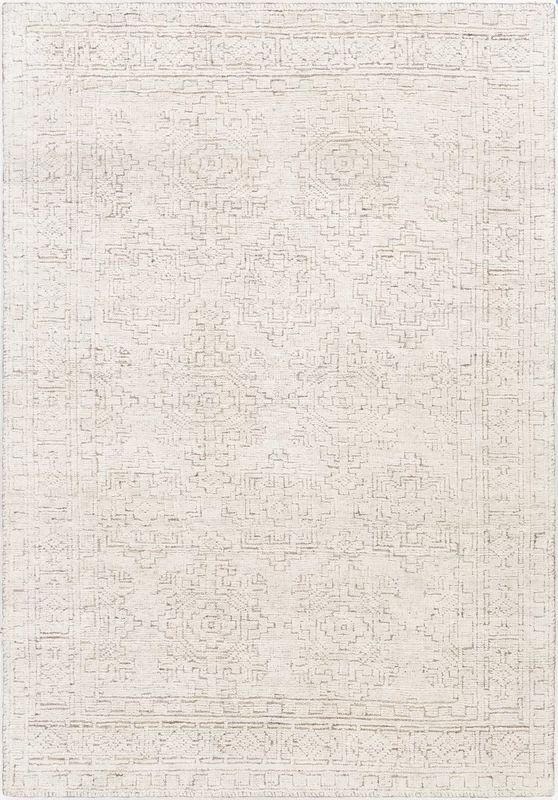 a white rug with an intricate design on the front and back side, in shades of beige