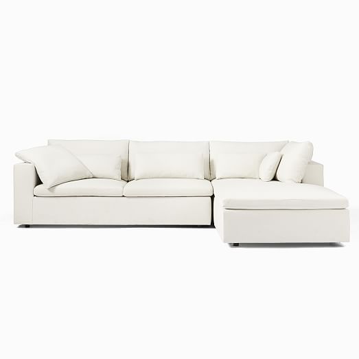 a white sectional couch with pillows on it