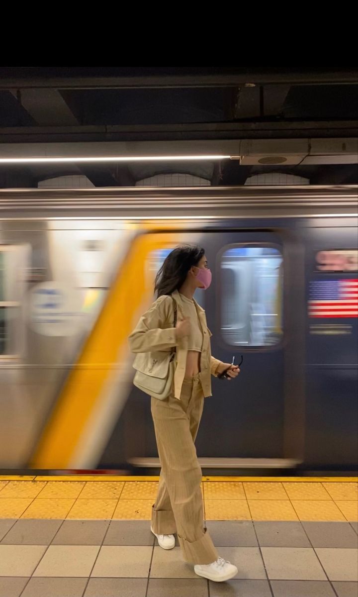 a woman standing in front of a subway train