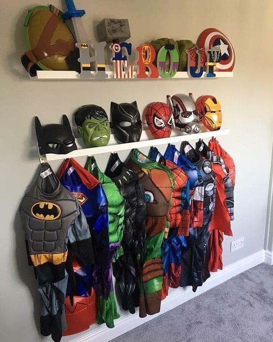 a wall mounted shelf filled with lots of different types of batman costumes and masks on it