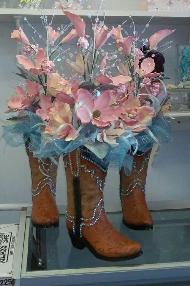 two cowboy boots with flowers in them on display