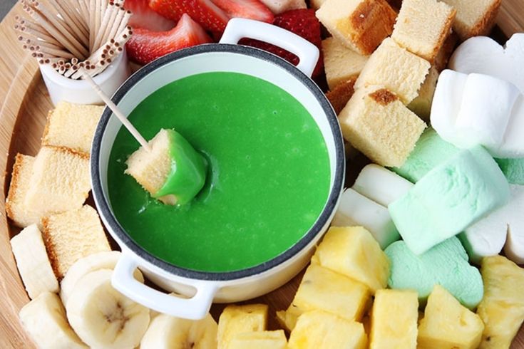 a bowl filled with different types of food on top of a wooden plate next to a spoon