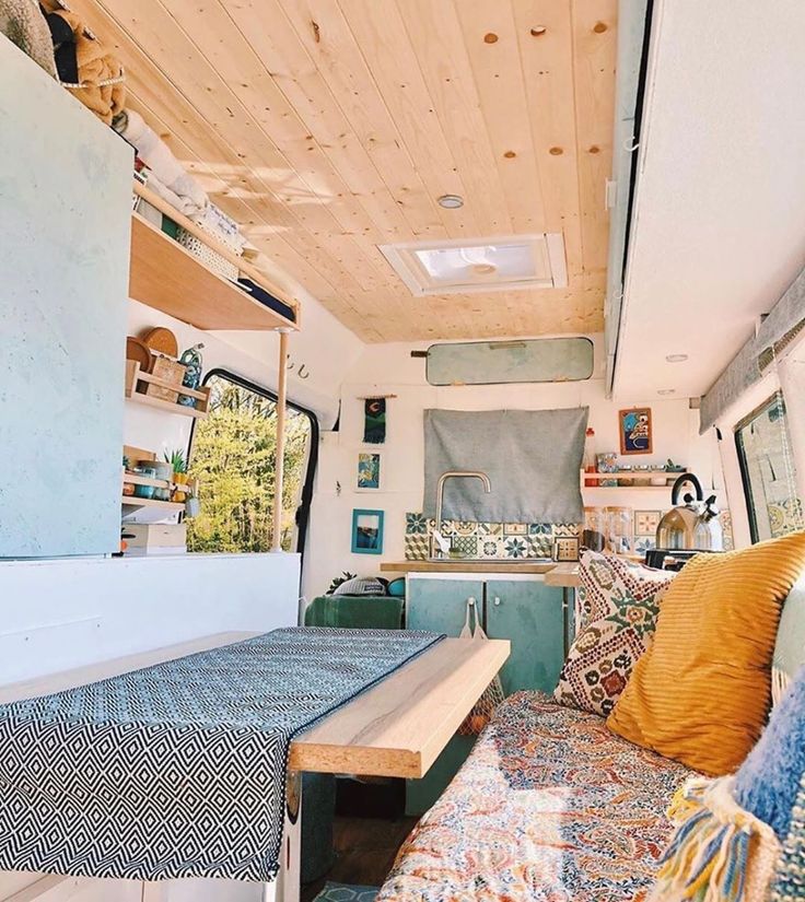 the inside of a camper with a bed and couch in it's center