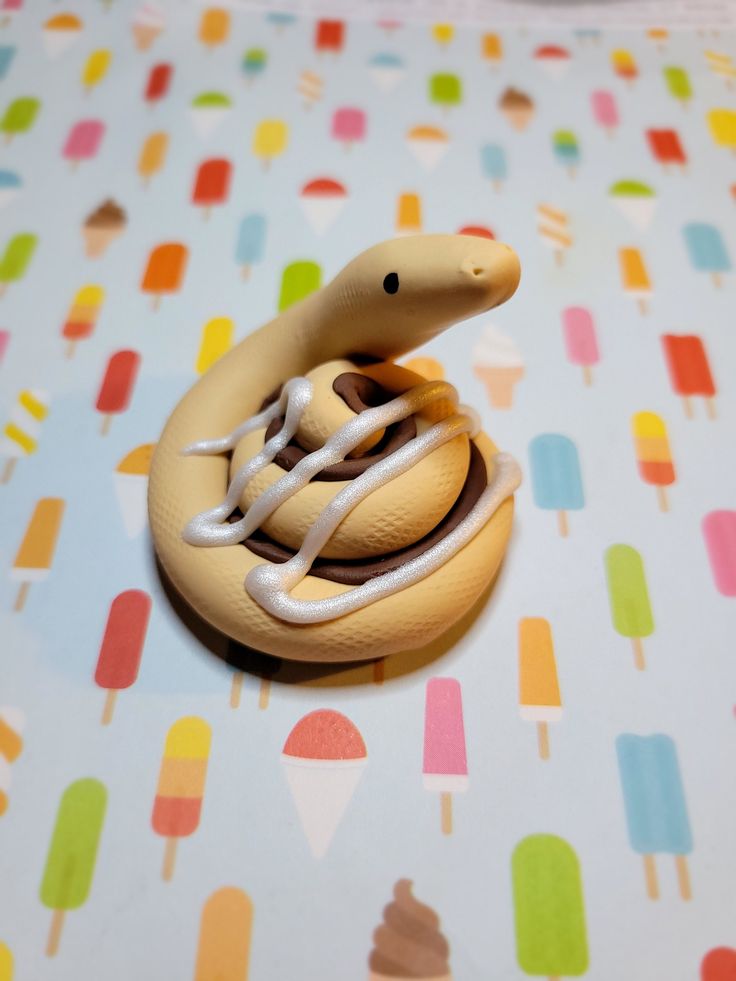 a toy snake is sitting on top of an icecream tablecloth with popsicles in the background