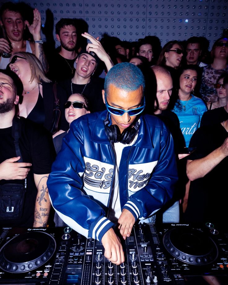 a dj mixing music in front of a crowd