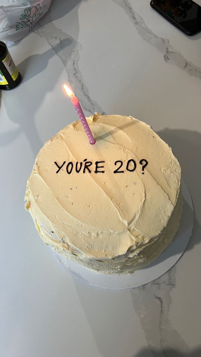 a birthday cake with the words you're 20 written on it and a lit candle