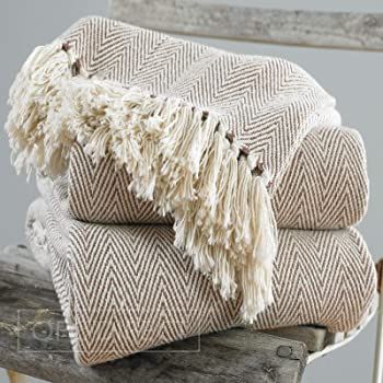 a stack of blankets sitting on top of a wooden bench